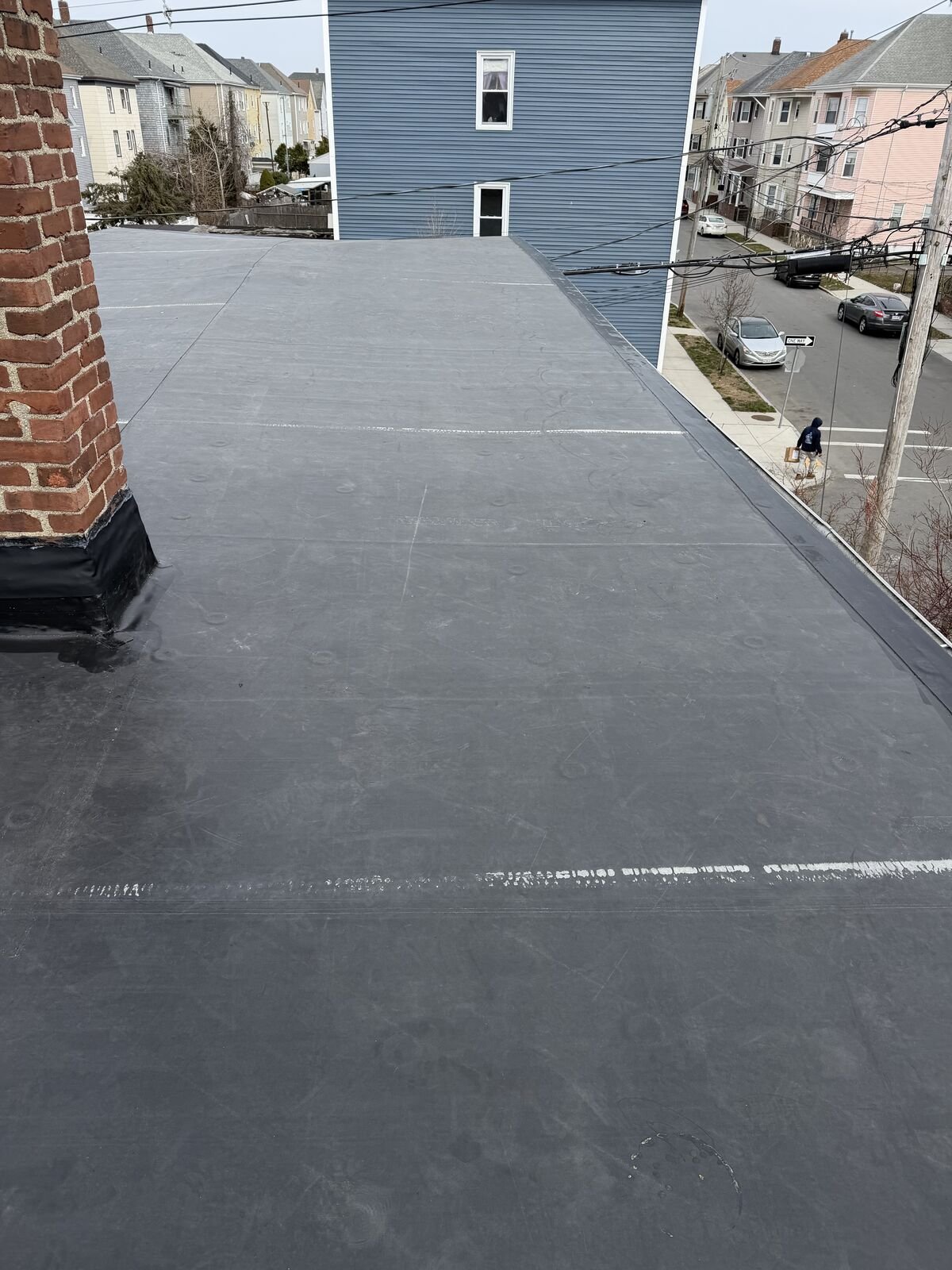 New EPDM rubber roof with chimney flashing on a multi-family home in New Bedford, MA