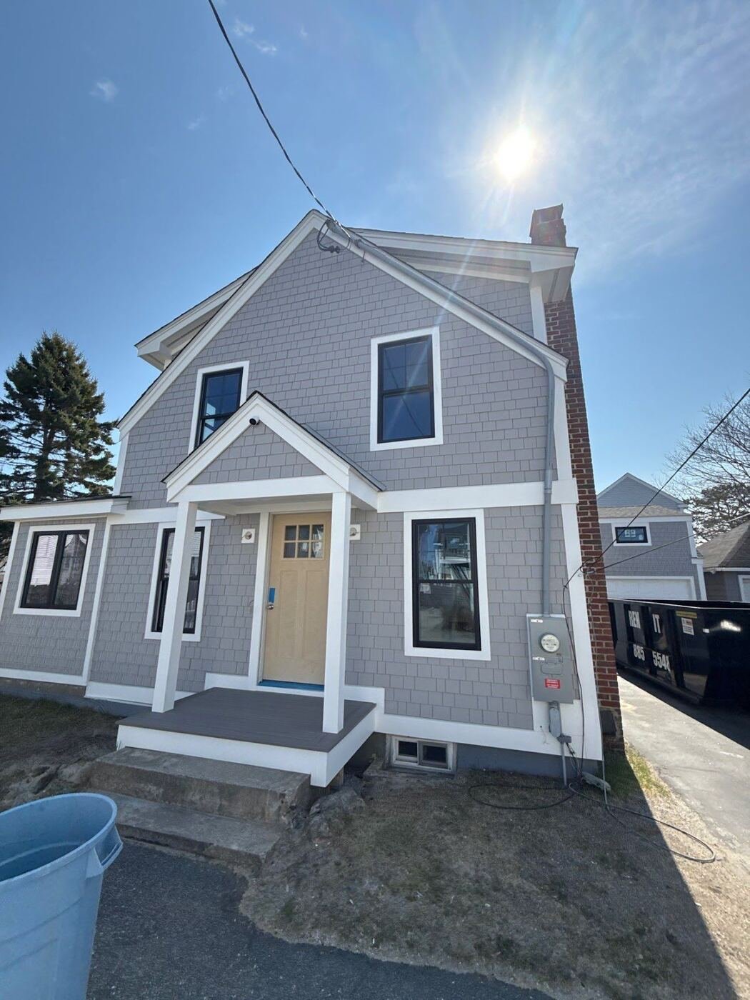 New gray vinyl siding with white trim on a two-story home in Lowell, MA